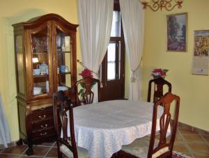 ein Esszimmer mit einem Tisch und einem Porzellankrank in der Unterkunft Apartment im englischen Stil mit Meerblick in Icod de los Vinos