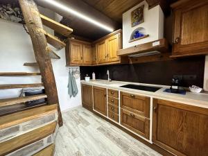 Una cocina con gabinetes de madera y un fregadero. en Rustico Toscano, en Castel Focognano
