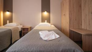 a hotel room with two beds with white towels on them at Hotel Gaja in Warsaw