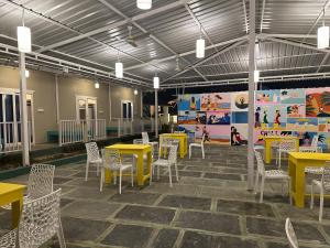 a dining room with yellow tables and white chairs at Coco Hostel Goa in Palolem