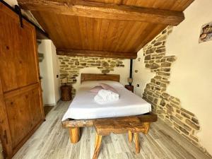 een slaapkamer met een bed en een houten plafond bij Rustico Toscano in Castel Focognano