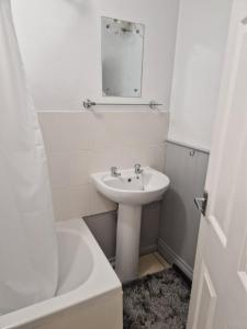 a white bathroom with a sink and a mirror at Opera Home in Peterborough