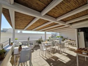 a patio with tables and chairs on a balcony at Carpe Diem B&B e Case Vacanza in Monopoli
