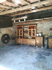 Habitación con armarios de madera en una pared de piedra. en Casa finca Pitusa, en Salvatierra de Miño