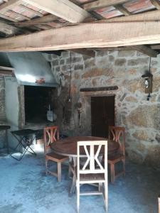 una mesa y sillas frente a un edificio de piedra en Casa finca Pitusa, en Salvatierra de Miño