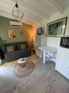 sala de estar con sofá y mesa en La Cabane, en Le Bar-sur-Loup