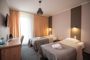 Hotel Gaja في وارسو: غرفة فندقية بسريرين ونافذة
