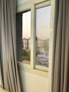 a window with curtains and a view of a city at Gardenia city , Nasr city in Cairo