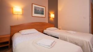 2 letti in camera d'albergo con asciugamani di Hotel Gaja a Varsavia