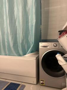 a washing machine in a kitchen with a blue shower curtain at Gardenia city , Nasr city in Cairo