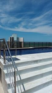 a swimming pool on top of a building with stairs at SUÍTE ITAPARICA Praia Dourada in Vila Velha