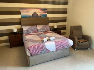 a bedroom with a bed with a striped wall at 24 Castle Hume Court Holiday House in Enniskillen