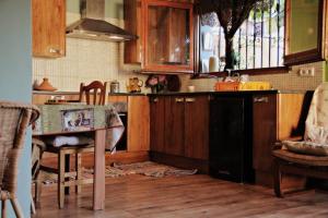 a kitchen with wooden cabinets and a black dishwasher at Casita de Bosque in Arbúcies