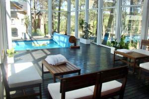 Großes Zimmer mit Pool, Tischen und Fenstern in der Unterkunft Manzanauno 108 in Mar de las Pampas