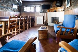 a room with chairs and a table and a fireplace at Casa de Aldea Menéndez in Cangas del Narcea