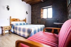a bedroom with two beds and a table and a window at Casa de Aldea Menéndez in Cangas del Narcea