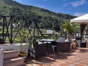eine Terrasse mit einem Tisch, Stühlen und einem Berg in der Unterkunft Apartment mit privatem Balkon sowie Meer- und Gebirgsblick im modernen Stil in Icod de los Vinos