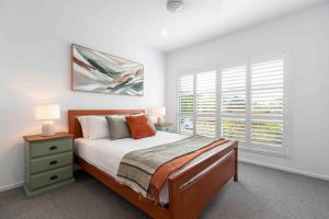 Habitación blanca con cama y ventana en Pet friendly Holiday home with pool on Alex, en Alexandra Headland