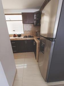 a stainless steel refrigerator in a small kitchen at Apartamento moderno en condominio Agualongo in Pasto