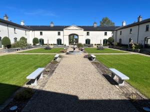 a park with benches in front of a building at 24 Castle Hume Court Holiday House in Enniskillen