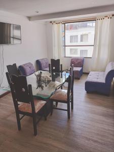 ein Wohnzimmer mit einem Tisch, Stühlen und einem Sofa in der Unterkunft Apartamento moderno en condominio Agualongo in Pasto