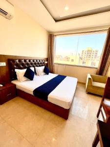 a bedroom with a bed with a large window at Hotel Woodcrest Zirakpur Chandigarh- Best Family Hotel in Chandīgarh