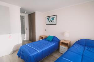 a bedroom with two beds with blue sheets at ARICA SUNSET in Arica