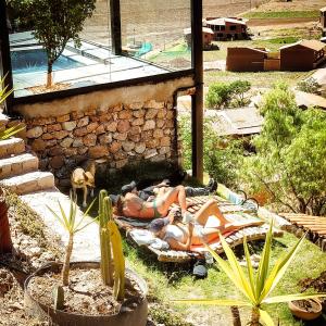 een groep mensen op chaises in een tuin bij Wolf Totem Steam Punk Guesthouse in Pisac