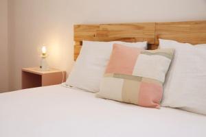 uma cama com almofadas brancas e uma cabeceira em madeira em Casa da Sé em Silves