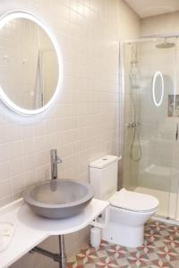 W łazience znajduje się umywalka, toaleta i lustro. w obiekcie Casa da Sé w mieście Silves