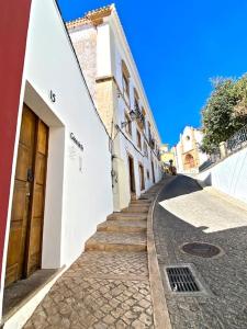 a cobblestone street in a town with white buildings at Casa da Sé in Silves