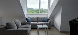 a living room with a couch and a table and a window at BARREIROS RUA Vila in Barreiros