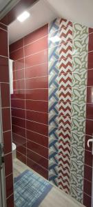 baño con ducha con pared roja en Guesthouse Tadic, en Guča