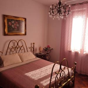 a bedroom with a bed and a chandelier at San Francesco in Rapolano Terme
