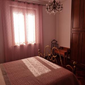 a bedroom with a bed and a chandelier and a window at San Francesco in Rapolano Terme +37 photos