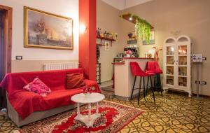 a living room with a red couch and a table at Hotel Albachiara in Viareggio