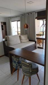 a living room with a couch and a table at Praia Dourada SUÍTE ITAPARICA in Vila Velha