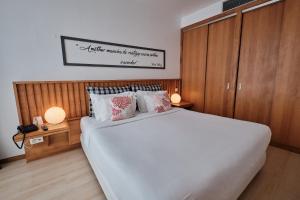 a bedroom with a large white bed and two lamps at Hotel Praia Marina by RIDAN Hotels in Praia da Vitória