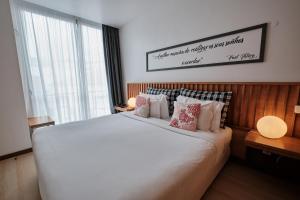 a bedroom with a large white bed with pillows at Hotel Praia Marina by RIDAN Hotels in Praia da Vitória
