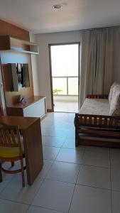 a bedroom with a bed and a desk and a television at SUÍTE ITAPARICA Praia Dourada in Vila Velha