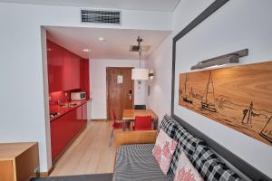 a living room and kitchen with a couch and a table at Hotel Praia Marina by RIDAN Hotels in Praia da Vitória