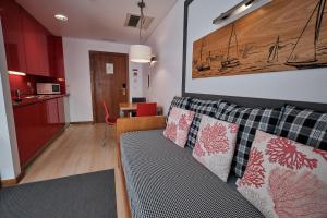a living room with a couch and a kitchen at Hotel Praia Marina by RIDAN Hotels in Praia da Vitória
