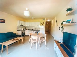 a kitchen and a living room with a table and chairs at Playa Maria Apartment 43 (Puerta al Cielo) in La Playa Calera +7 photos