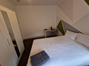 a bedroom with a white bed with a pillow on it at Brewery rd Double room in Plumstead