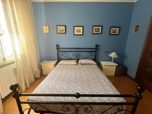 1 dormitorio con 1 cama en una habitación azul en Casa Rossa, en San Leonardo