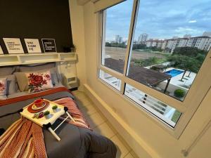 Un dormitorio con una cama y una ventana grande. en Apartamento 133 Magnífico!, en Ribeirão Preto