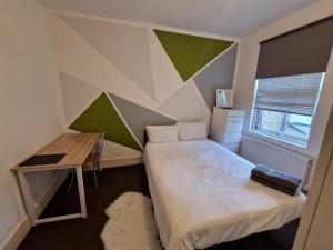 a small bedroom with a bed and a desk at Brewery rd Double room in Plumstead