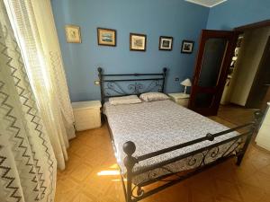 1 dormitorio con cama y pared azul en Casa Rossa, en San Leonardo