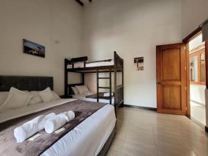 a bedroom with two bunk beds and a door at HOTEL ALTIPLANO VILLA DE LEYVA in Villa de Leyva