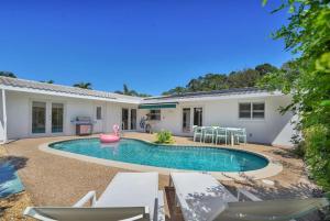 a swimming pool in the backyard of a house at The Dreamcatcher - 4 Bed, 2 Bath, Private Heated Pool, BBQ, Game Room, Park in Fort Lauderdale
